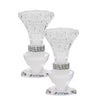 Two clear crystal candle holders with decorative bands on a white background